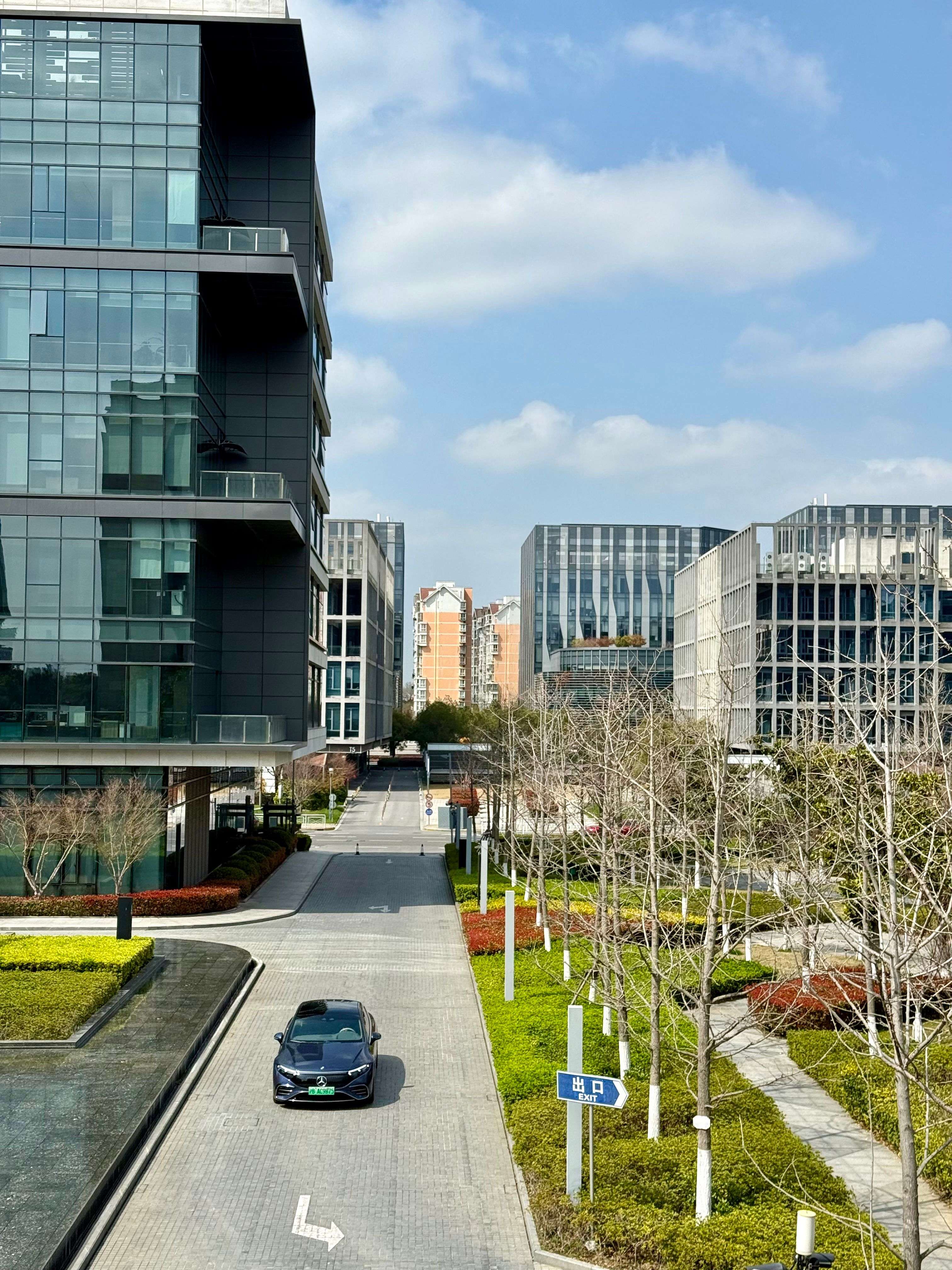 Modern glass office campus with landscaped courtyards and an internal exit road — the everyday corporate environment EntryBit secures